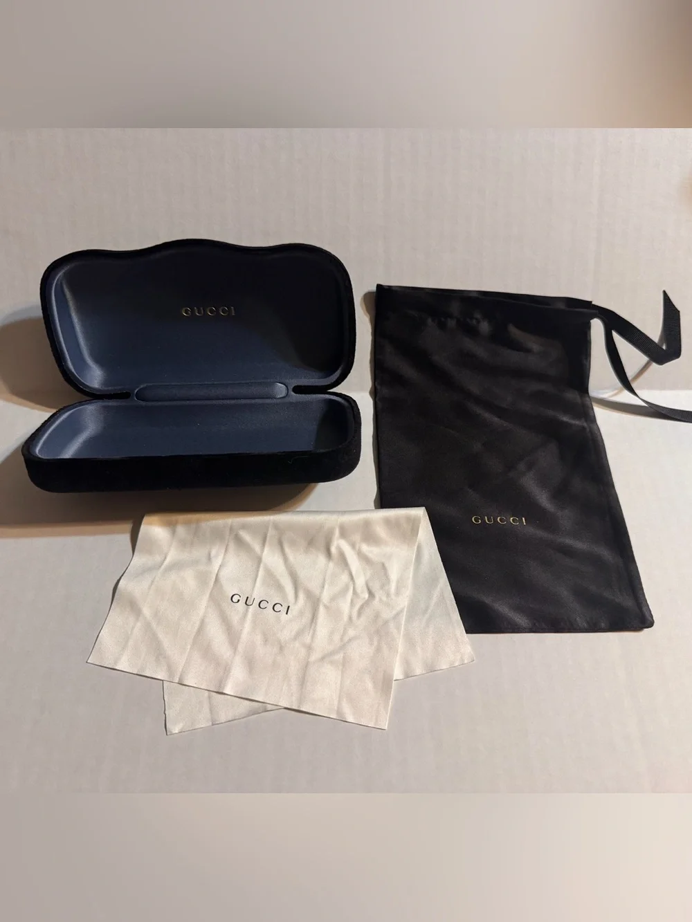 A Gucci Eyewear Case in Black and Dark Gray with Gold Logo